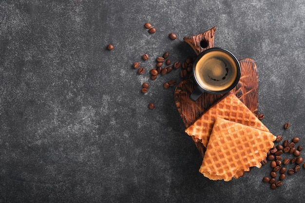 Coffee and dutch waffles Espresso coffee and dutch waffles or syrupwaffles cookies with chocolate on old on black concrete table Perfect syrupwaffles cookies for Breakfast Top view Mock up