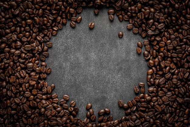 Coffee frame on stone background Roasted beans scattered with round copy space in center