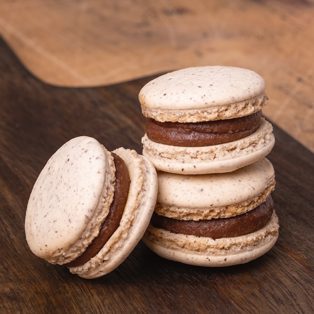 Coffee in glass cup and chocolate macarons on wooden background. Cozy autumn composition - Image