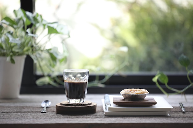 Coffee glass cup and Egg tart dessert with notebooks