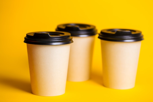 Coffee to go. paper cup with coffee on a yellow background.