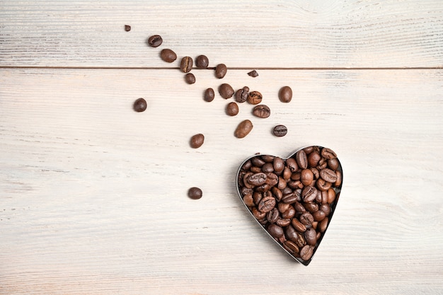 Coffee heart on a light background. A flying heart with a tail of scattered grains