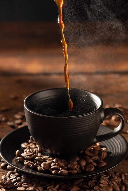 Coffee hot and Black Cup pouring coffee into a black cup on rustic wood dark food style photo selective focus