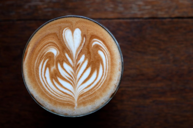 Coffee latte art on wood table background