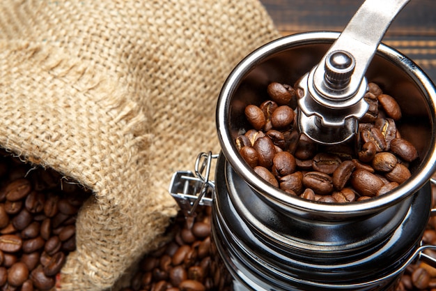 Coffee mill and roasted beans on wooden background