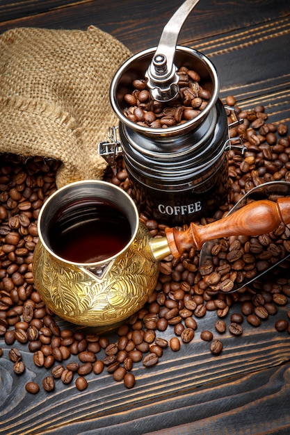 Coffee mill and roasted beans on wooden background