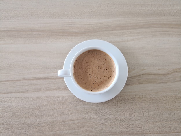 Coffee mocha in a white cup on a brown wooden table.