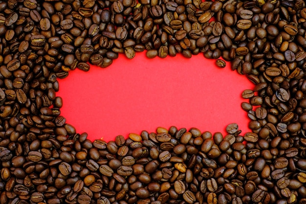 Coffee mockup.Roasted coffee grains and copy space on a red background. Coffee drink