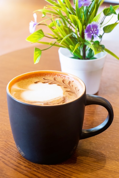 Coffee mug black on brown wooden table background. Relaxing Concept.