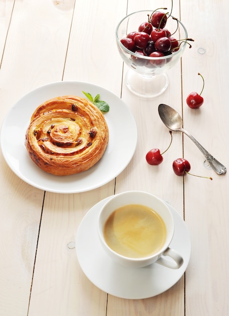 Coffee in a mug, cupcake with cinnamon cherries