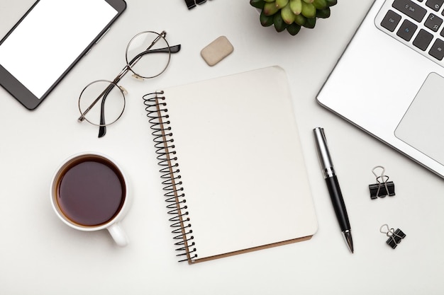 Coffee, notepad and pen on white table