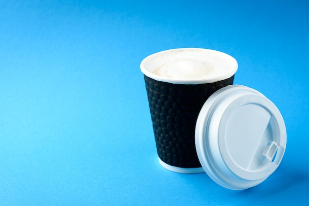 Coffee paper cup on blue background.