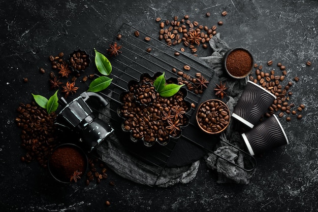 Coffee Roasted fragrant coffee beans and coffee maker on a black stone background Top view Free space for your text