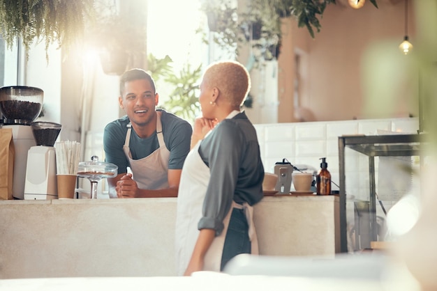 Coffee shop barista and team with small business and entrepreneur employees chat while working and server Entrepreneurship food industry and team with communication man and woman talking in cafe