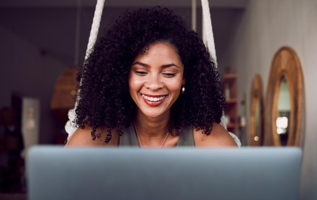 Coffee shop working and face of black woman with laptop smiling happy and excited to start project Entrepreneur freelancer and businesswoman typing writing and reading work on computer in cafe