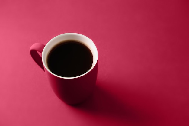 Coffee in viva magenta cup on monochrome background