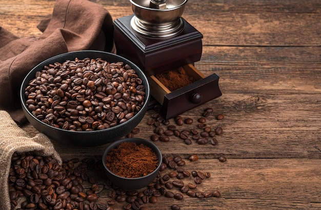 Coffee wall with coffee beans and a coffee grinder on a wooden brown wall. Side view, horizontal with space to copy.