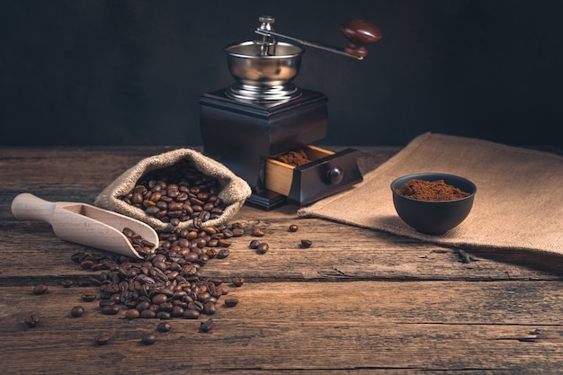 Coffee wall with coffee grinder and beans on wooden table with copy space. Side view.