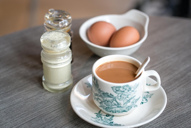 Coffee with boiled eggs soy sauce and white pepper on table