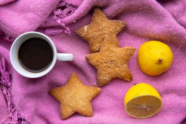 Coffee with cookies and lemon on a winter scarf