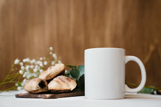 Coffee with croissants and blurred flowers at the background