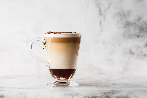 Coffee with Irish whiskey and whipped cream in glass isolated on bright marble background. Overhead view, copy space. Advertising for cafe menu. Coffee shop menu. Horizontal photo.