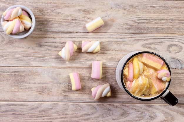 Coffee with marshmallows on white wood table