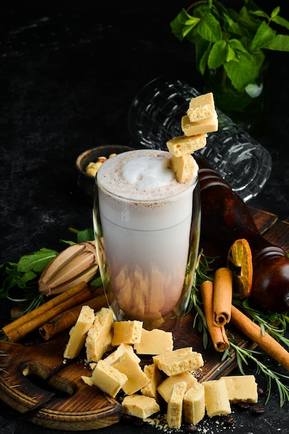 Coffee with milk and white chocolate Cocoa In the glass Top view On a black background