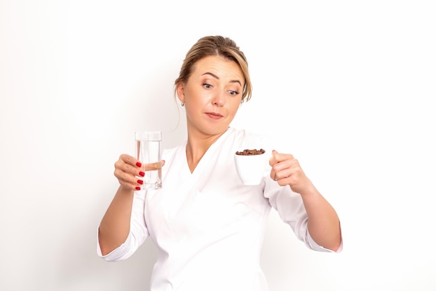 Coffee with water the female nutritionist holds a cup of coffee beans and a glass of water in her ha