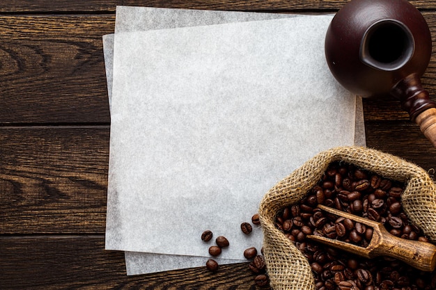 Coffee wooden background with empty blank paper sheets copy space turkish cezve pot wood spoon and r