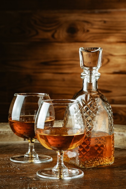 Cognac or whiskey in glasses on rustic table