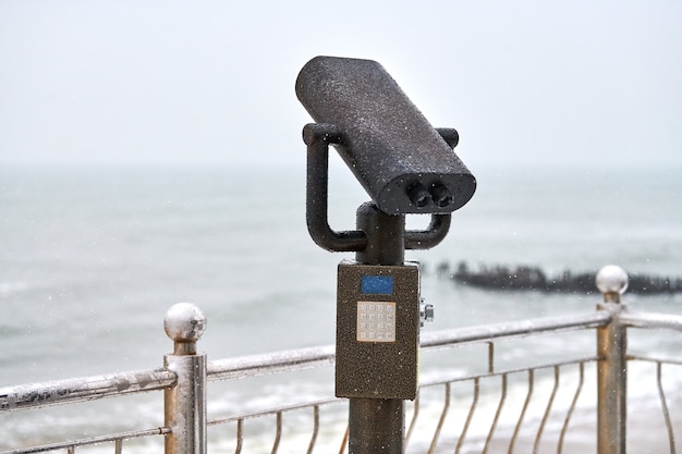 Coin-operated binocular viewer next to waterside promenade