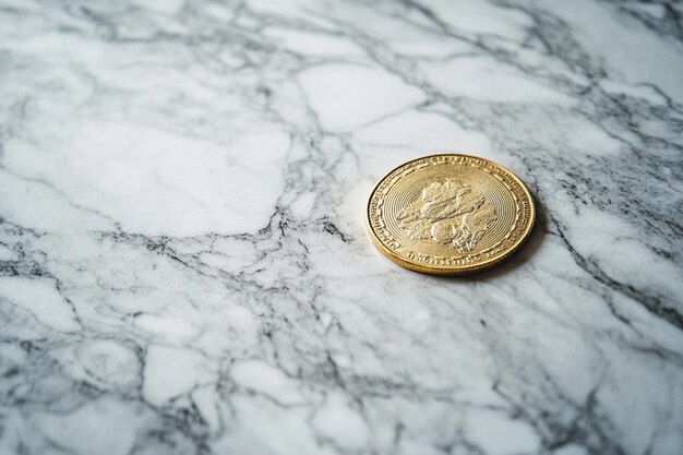 a coin that says quot gold quot on it is on a marble table