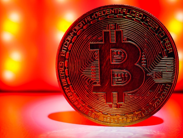 A coin with bitcoin symbol on red light. Concept of a cryptocurrency market crisis.