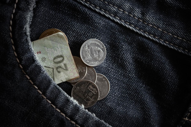 Coins and banknote crumpled in pocket of blue jeansConcept of Economic recessionunemploymentretirement global economic crisis