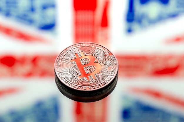 coins Bitcoin over Great Britain and the British flag, concept of virtual money, close-up. Conceptual image.