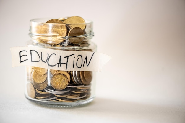 Coins in glass jar with education label Financial concept