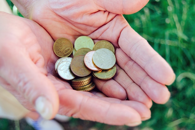 Coins in old granny hands close up