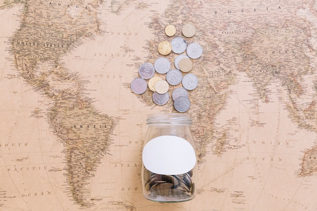 Coins and an open jar on world map