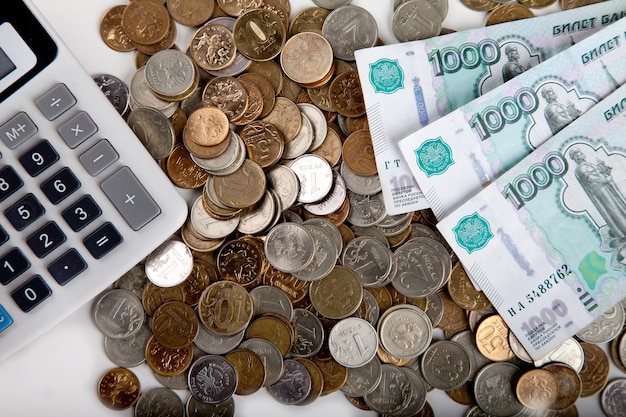 Coins ruble banknotes and calculator on white