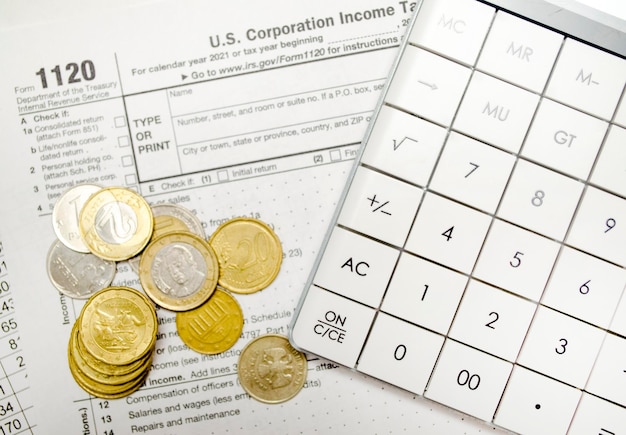 Coins with calculator and tax form on white background