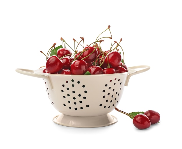 Colander with sweet cherry on white