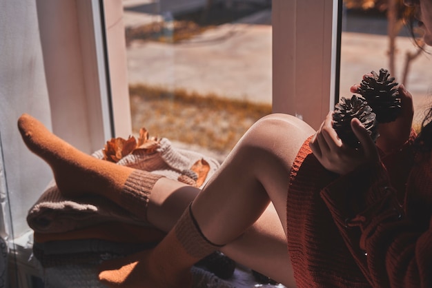 Cold autumn days  a young multiracial female drinks coffee in a cozy windowsill middleeastern or mix...