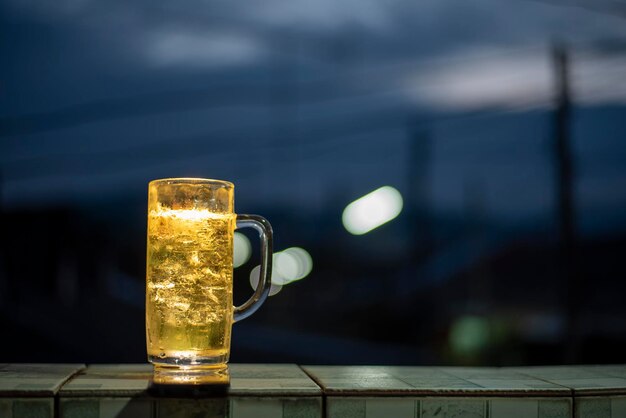 Cold beer served in a pitcher with ice on a black backgroundxA