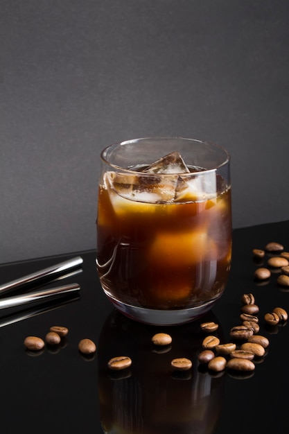 Cold brew coffee in the drinking  glass on the black  background. Location vertical.