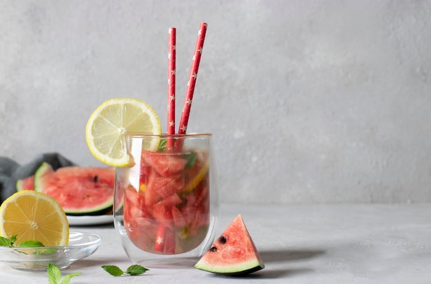 Cold Bright Watermelon Mojito cocktail with mint lemon slices and drinking straw