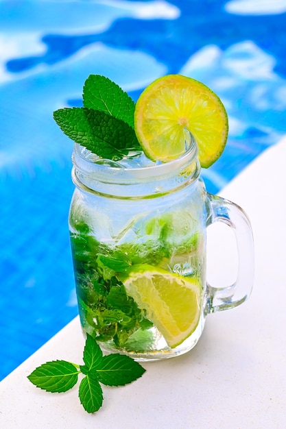 Cold drink lemonade on the background of the pool