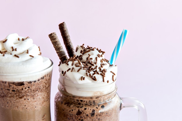 Cold frappe coffee with whipped cream. Pink background with iced frappuccino.