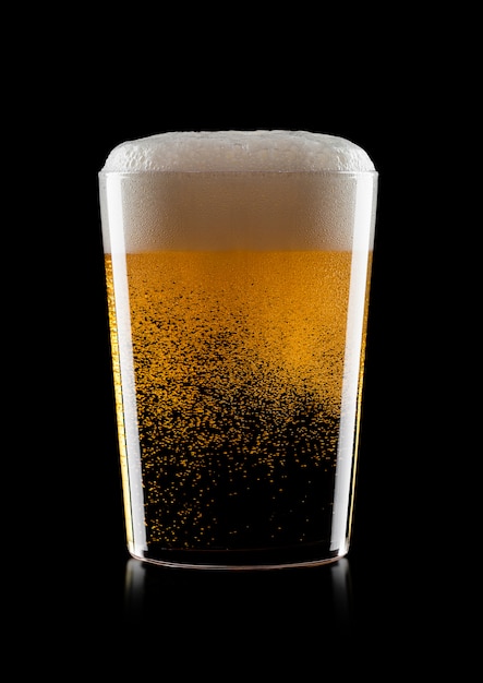 Cold glass of lager ale craft beer with foam and bubbles on black background