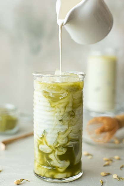 Cold green matcha with milk in a tall glass